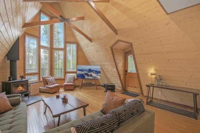 Living room seating around the wood-burning stove with mountain art